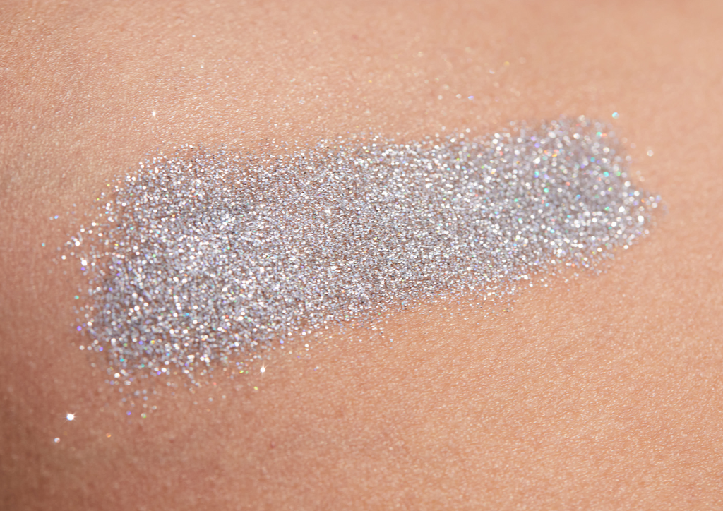 Product image of TINTYKIT LIVING GLITTER biodegradable glitter. Product variant: Silver Sea Sparkle. Artistic view of glitter sparkling on a woman's skin.