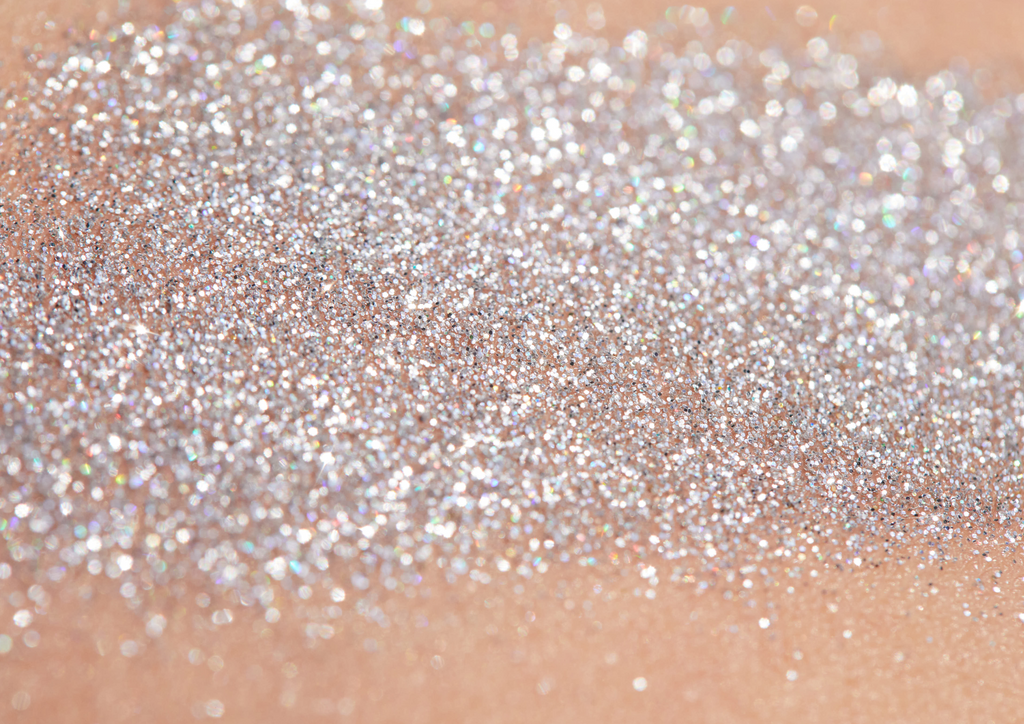 Product image of TINTYKIT LIVING GLITTER biodegradable glitter. Product variant: Silver Sea Sparkle. Artistic view of glitter sparkling on a woman's skin.