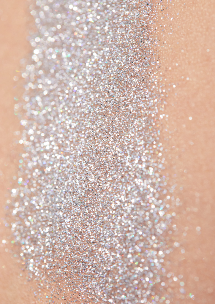 Product image of TINTYKIT LIVING GLITTER biodegradable glitter. Product variant: Silver Sea Sparkle. Artistic view of glitter sparkling on a woman's skin.